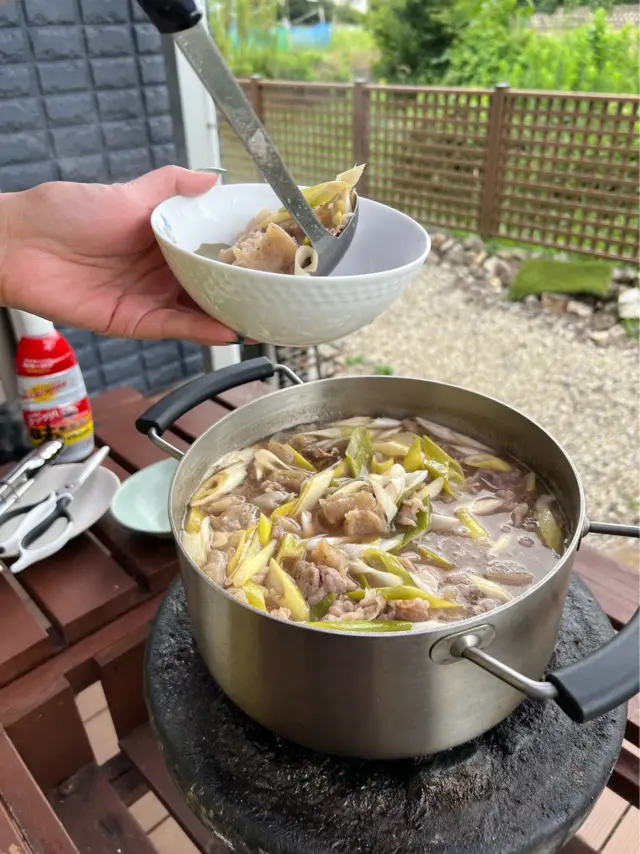 芋煮を鍋から器によそう写真