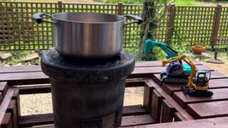 鍋の横に重機のおもちゃが2つ並んでいる