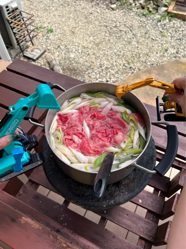 芋煮の鍋に重機が近づいている写真
