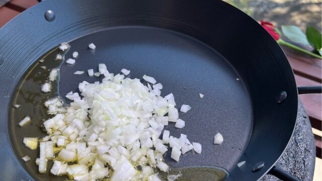 鍋にみじん切りの玉ねぎとニンニクを入れて炒めている写真