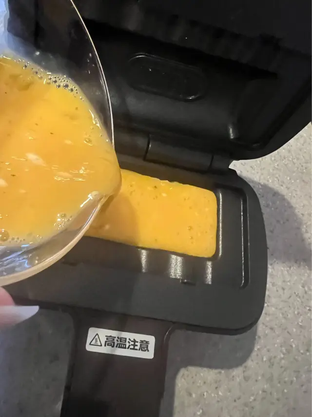 ホットサンドメーカーに卵液を入れている写真