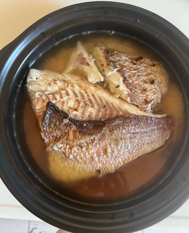 土鍋に米と出汁と調味料と鯛の切り身を入れた写真