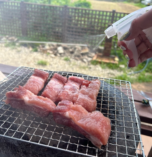 霧吹きで日本酒を肉に吹き付ける写真